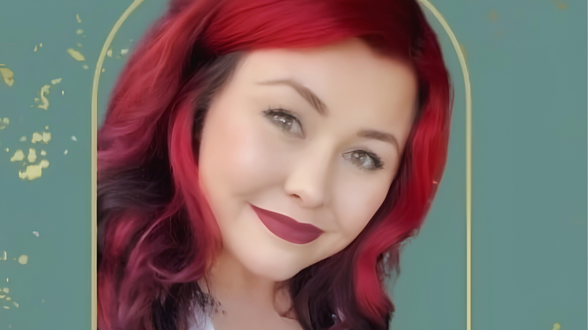Portrait of Cassie Phillips with long wavy red hair and dark lipstick against teal background with gold arch frame.