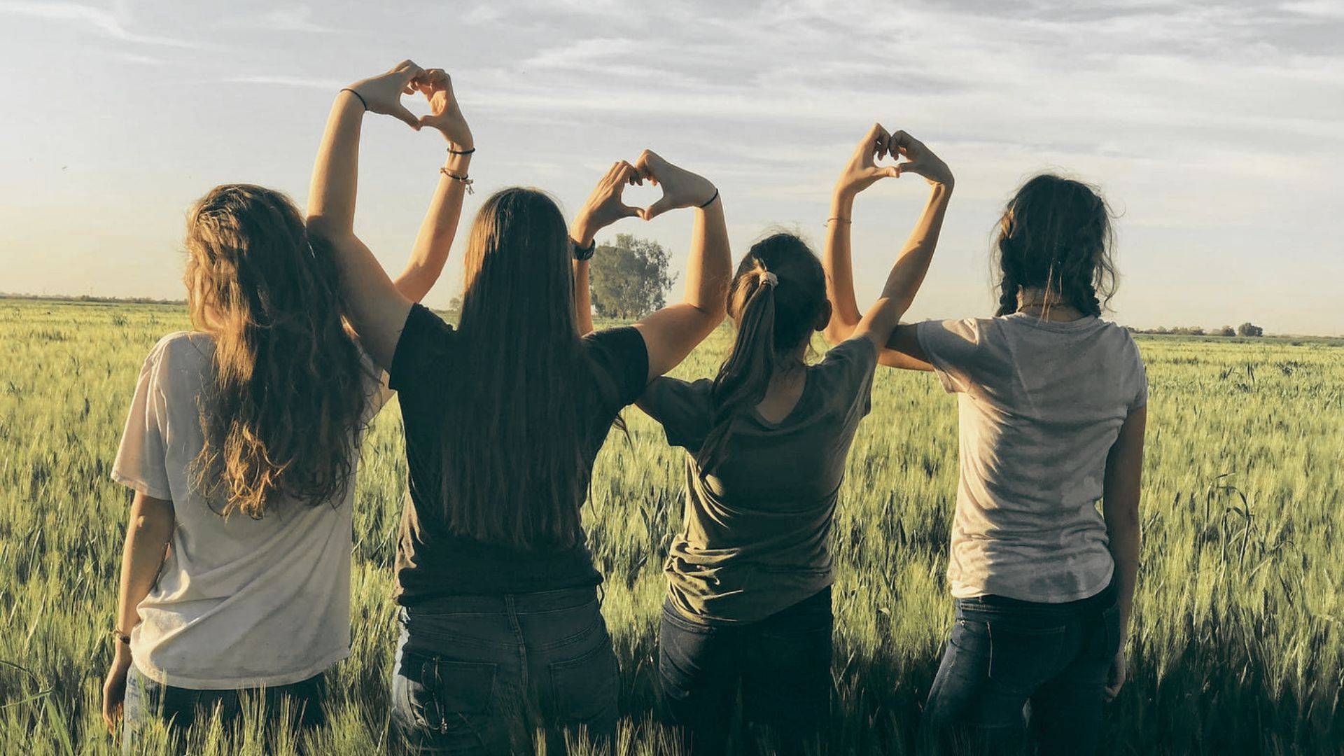 Four friends posing together on a farm.