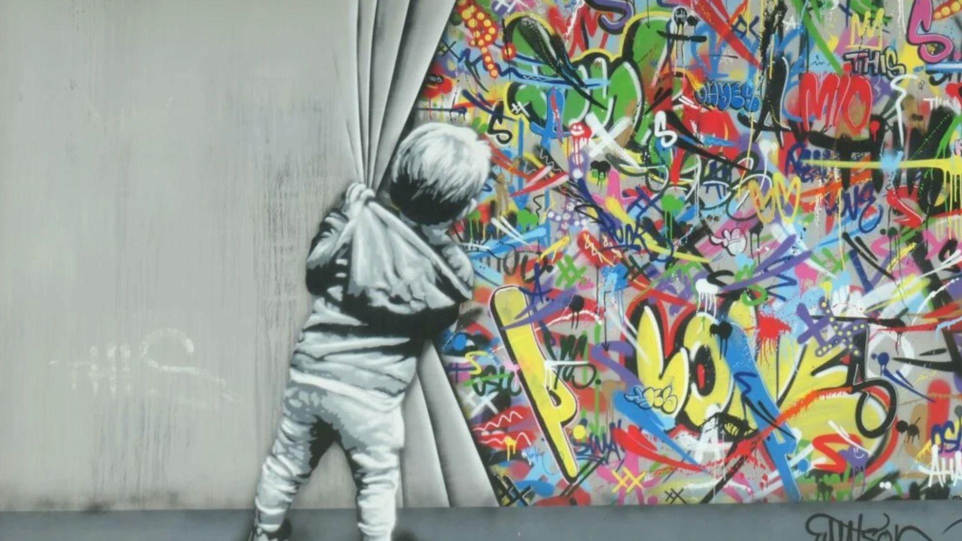 A child peeks behind a curtain revealing a vibrant graffiti wall