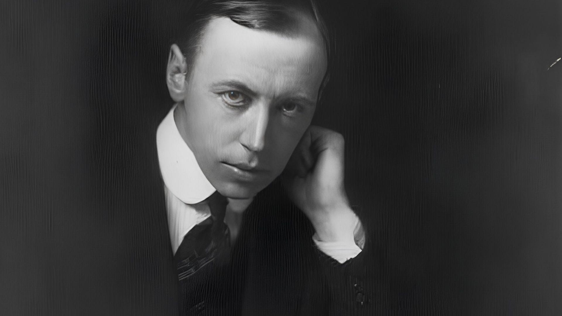 Black and white portrait of poet Alfred Noyes in suit, resting head on handFile name: alfred-noyes-black-white-portrait