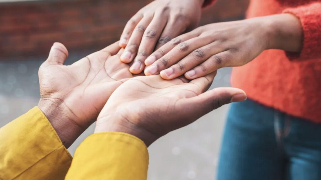 Hands gently touching an open palm in a supportive gesture