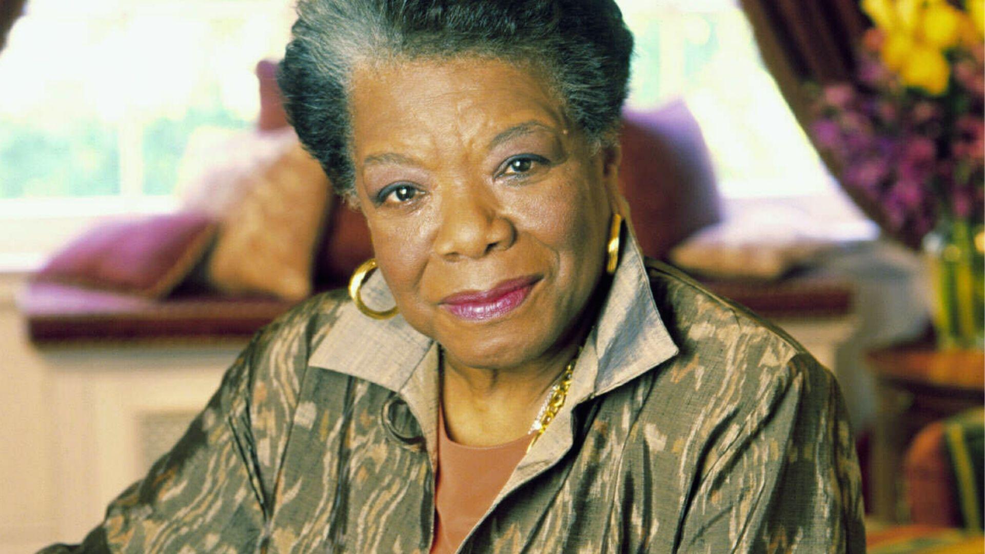 Maya Angelou seated indoors wearing a patterned jacket and gold earrings