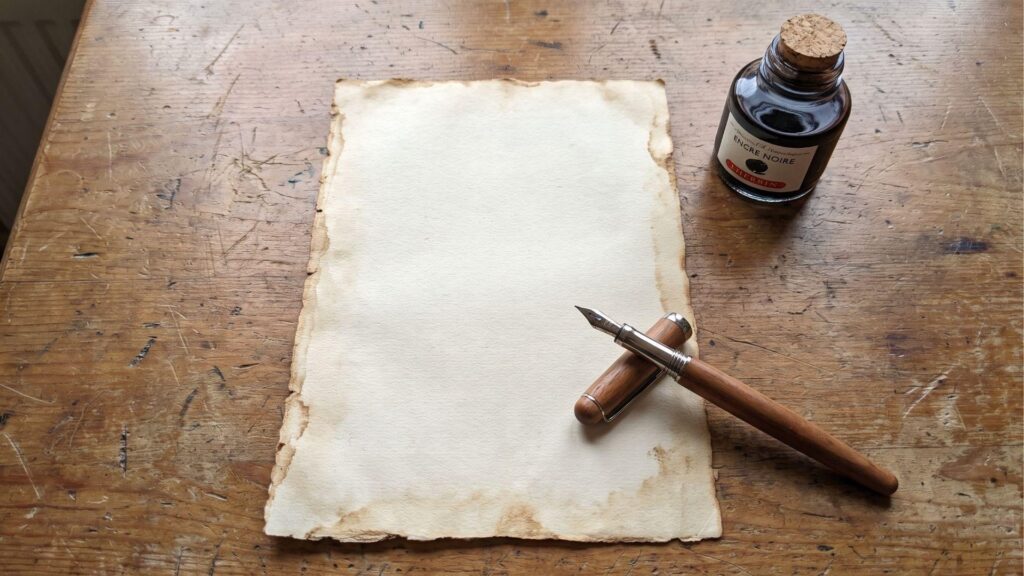 blank page with an ink bottle and a fountain pen