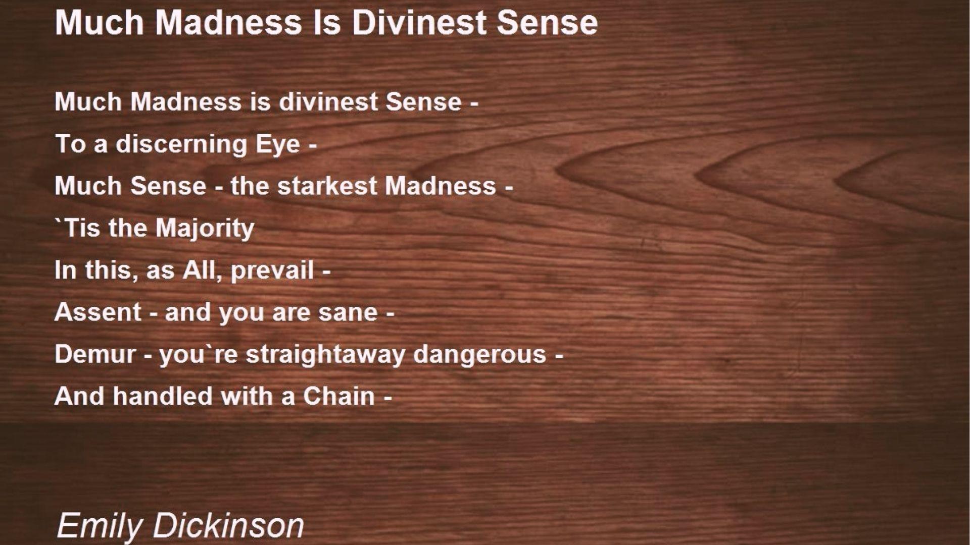 Emily Dickinson’s “Much Madness Is Divinest Sense” poem on a dark wooden background