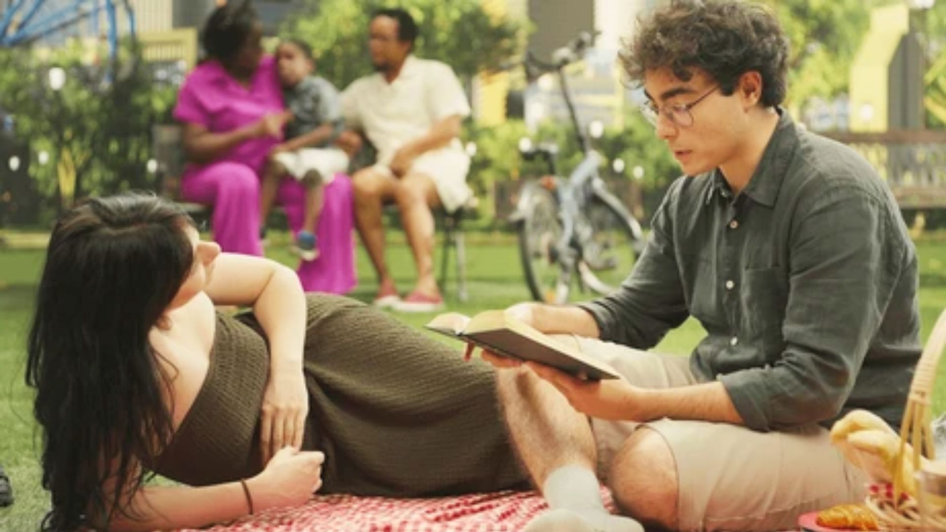 A man reads an onomatopoeia poem aloud to a woman relaxing.